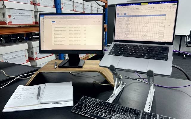 Records desk with screens, a notebook and archive boxes behind